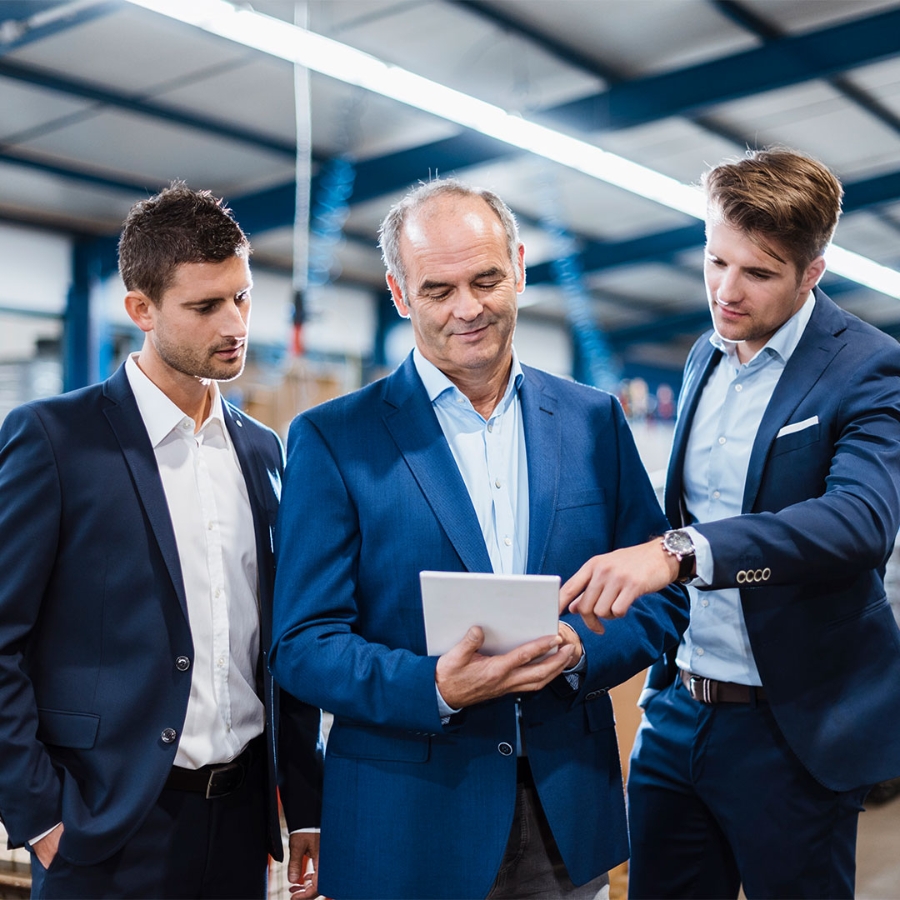 Businessmen using tablets communicate with one another